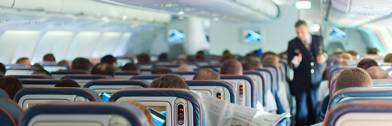 passenger on plane with air steward in background 