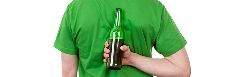 Person hiding a beer behind his back 