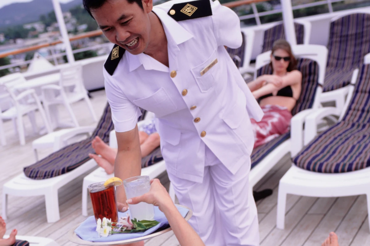 waiter giving woman a drink on cruise ship