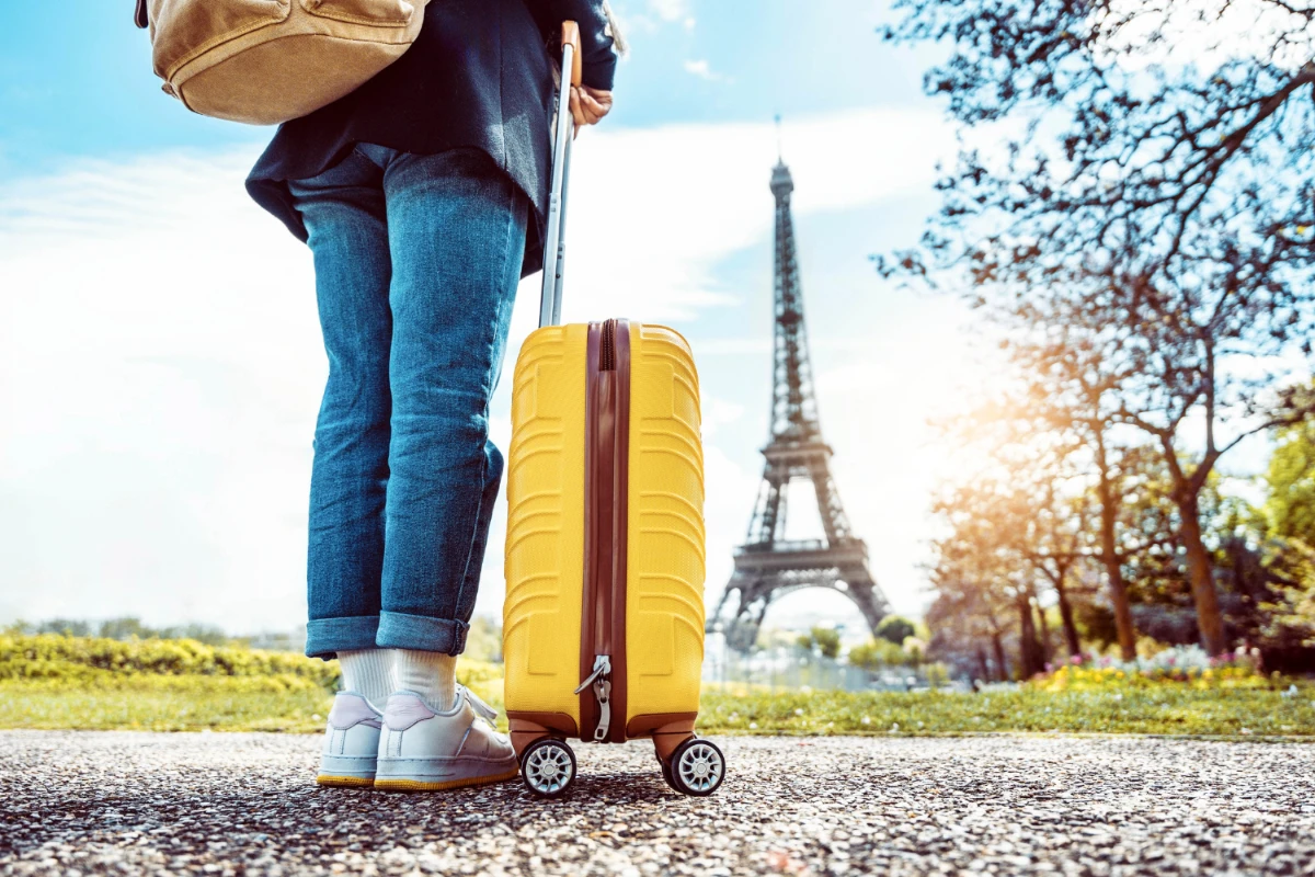 woman in paris with yellow suitcase