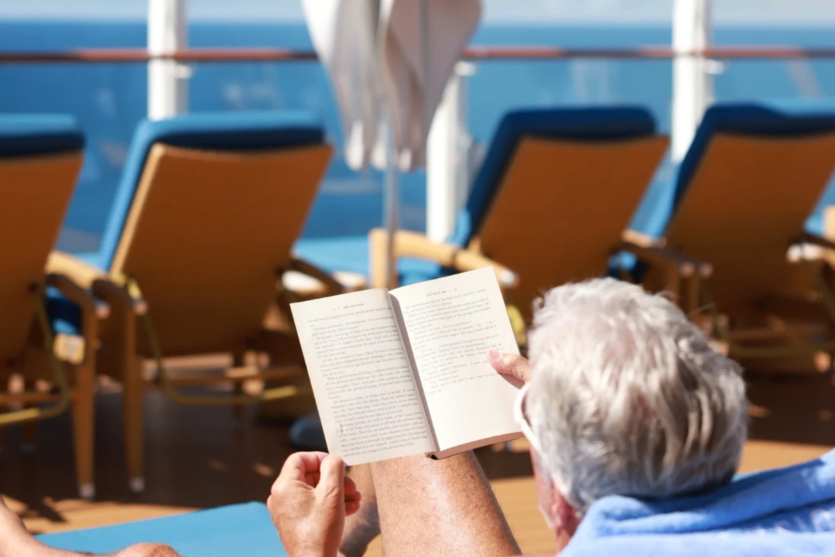 man reading book on cruise